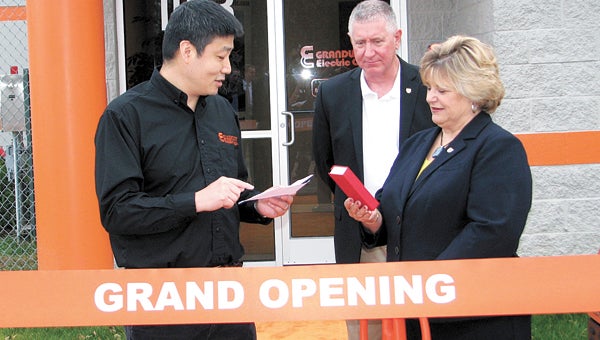 David Du, president of Grandwatt Electric Corp., presents Mayor Linda T. Johnson with a special bookmark before the two cut a ribbon on Friday. Looking on is City Councilman Roger Fawcett.