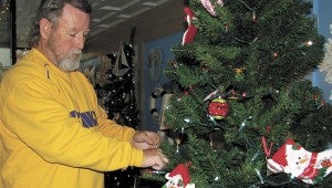 Billy James of All About Virginia & More trims the tree in the front window of the North Main Street store. Businesses and venues throughout downtown Suffolk will offer special deals through the weekend for shoppers and diners.