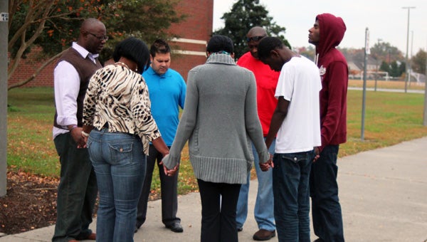 Nycholle Gater, organizer of the prayer vigil at Nansemond River High School, joins hands Saturday with husband Darrick and their children, Colby, Devin and Amber, as well as two local pastors, Anthony Vandyke of New Community Christian Center and Steve Bellavia of 3n1 Church. (Matthew A. Ward/Suffolk News-Herald)