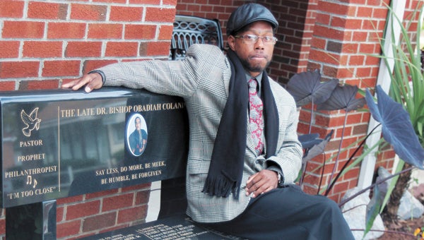 Antwan Robinson Sr. sits on a bench at his church honoring its late founder, Faith Temple Ministries’ Dr. Obadiah Colander. Robinson, who came to the church after struggling with drugs and serving prison time, said the bishop inspires his ministry work with at-risk youth.