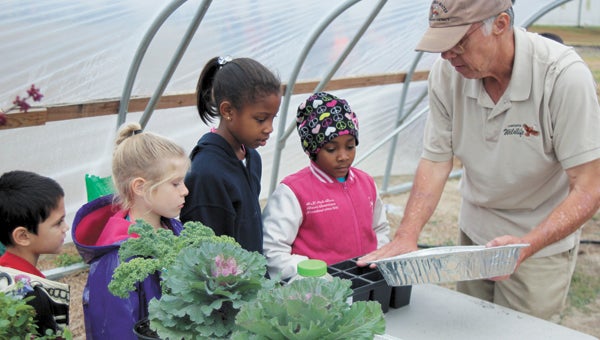 Eric Henderson, Madison Pismeny, Mya Langston and Makiya Underwood of Southwestern Elementary School learn about growing plants in a greenhouse from Bob Glennon, who works for Virginia Tech in Smithfield. The students were among all second-graders from city schools to attend Farm Day at the Virginia Tech Research Farm on Hare Road Wednesday and Thursday.