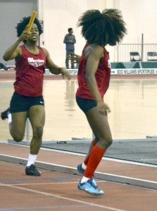 Nansemond River High School senior Mia McClain hands off to sophomore Brandee Johnson in a relay event during Thursday’s Ironclad Conference indoor track and field championships.