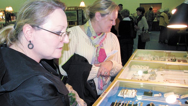 Kim Hepler and Nancy Winchell look at jewelry pieces during the Suffolk Art League’s Antiques Show and Sale last year. The annual event is back for its 31st installment later this month at King’s Fork Middle School.