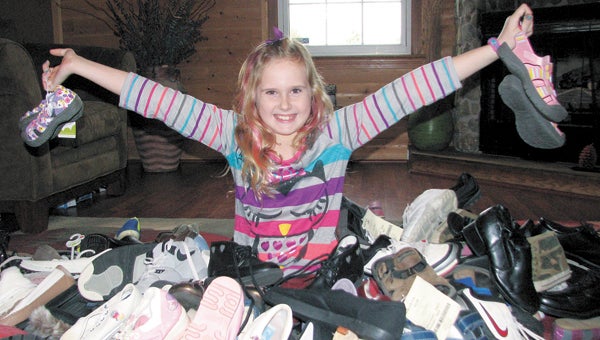 Peyton Baines shows off some of the more than 170 pairs of shoes she has collected in an effort to help people who don’t have shoes. She said she wanted to find a way to give back after many people helped her family during her mother’s battle with cancer.