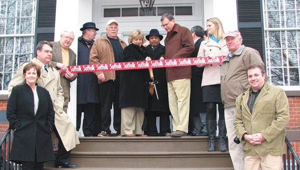 City officials join Riddick’s Folly board members and staff in cutting the ribbon on the museum’s new entrance. From left are board members Jane Smith and Marcus Gersbach, Riddick’s Folly director/curator Edward King, Councilmen Charles Parr and Jeffrey Garden, Mayor Linda T. Johnson, Councilman Lue Ward, Folly Board Chairman Jay Butler, Councilman Mike Duman, and Folly Board members Jenna McKenney, Larry Riddick (a distant cousin of the Riddicks who built the home) and Kevin Sary.