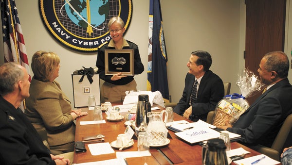 Rear Adm. Diane E. H. Webber, commander of U.S. Navy Cyber Forces, which moved into the former U.S. Joint Forces Command facility in North Suffolk, presents Mayor Linda T. Johnson with a “command coin,” during a visit by the mayor and other city officials. (U.S. Navy photo by Robin Hicks)