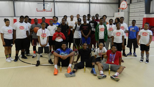 The majority of participants in Rev. David Wade's second annual 3-on-3 youth basketball tournament pose for a picture following the championship game on Saturday in Suffolk.