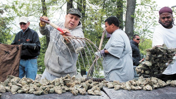 Volunteers load on fresh oysters during last year’s roast; this year’s Chuckatuck Ruritan Club event is on April 9.
