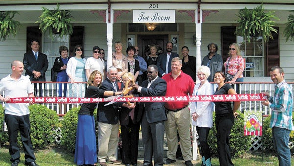 City officials and employees help Diane Kippes snip the ribbon at Stillwater House Tea Room on Prentis Street last week.