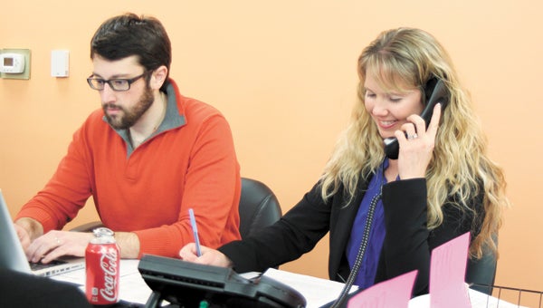 At the Harbour View campus, Liberty Baptist Church volunteers Shane Hess and Cathy Moffat man the phones on Tuesday to register families to receive free food for Easter.