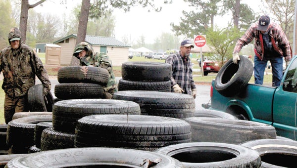 During a “tire amnesty” event at Bennett’s Creek Park on Saturday, part of The Great American Cleanup and Earth Day activities, Mike Lane, Jimmy Fanny, Russ Dail and Linwood Dail add to stacks of old tires bound for recycling facilities.