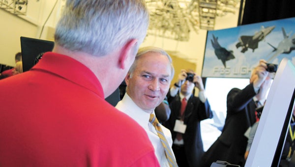 At the Lockheed Martin Center for Innovation in North Suffolk on Tuesday, former Air Force pilot Anthony Stutts shows Randy Forbes the controls as the congressman pilots an F-35 cockpit demonstrator.