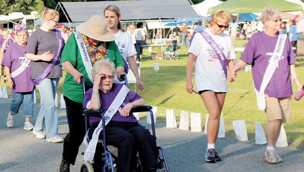 Caregivers and survivors walk the survivors’ lap at the 2013 Relay For Life at Bennett’s Creek Park. Any survivor can sign up for free to participate in the survivors’ activities at Relay, which include a dinner and free raffle of gift baskets.