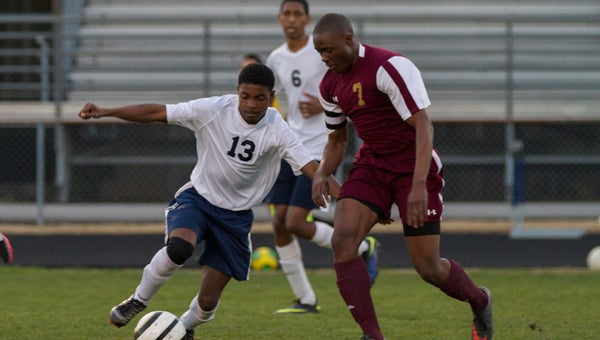 Lakeland High School freshman Donell Blount, left, tries to beat King’s Fork High School senior Oludare Olugbemi to the ball on Tuesday. The visiting Bulldogs won 2-0. (Jeremy Brant photo)