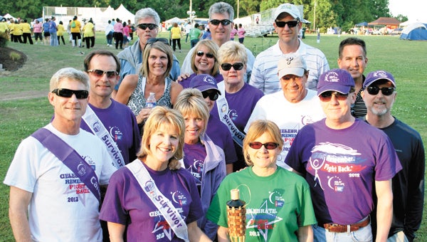 Barb Melton, second from left on the front row, and other members of Team Riverfront pause at the 2013 Suffolk Relay For Life to honor Maxie McFarland, who later lost her battle with cancer on Nov. 8.