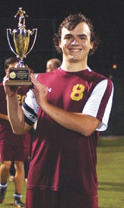 King's Fork High School senior team captain Corbin Morse hoists the trophy signifying his team's 2-1 conference soccer tournament title win in quadruple overtime on Friday at Christopher Newport University. (Caroline LaMagna photo)