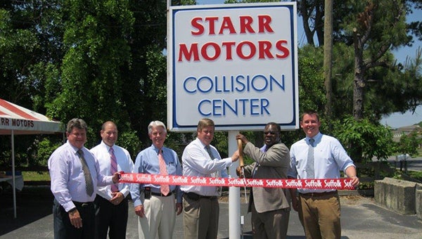 Vice Mayor Charles Brown helps Starr Motors cut the ribbon at its new collision center on Pruden Boulevard during an event Tuesday.