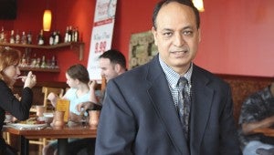 Paul Chhabra, seated inside the restaurant during a recent busy lunch period, owns Rajput Indian Cuisine at Harbour View—Suffolk's first Indian eatery.