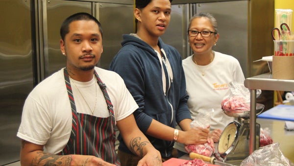 At Totoy's Filipino Store in North Suffolk, Lynn Carbonell helps her sons Reggie Felipe—on the knife—and Ryan Felipe prepare some tasty traditional dishes.