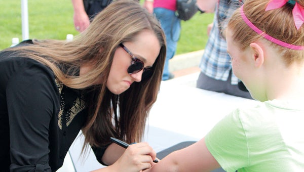 During Smithfield’s homecoming for Bria Kelly on Saturday, the star from “The Voice” signs the arm of Meagan Yoakum, 10. (MATTHEW A. WARD/SUFFOLK NEWS-HERALD)