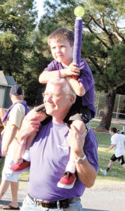 At Bennett’s Creek Park on Friday with Brayden Fusco, 5, his great-nephew, hoisted atop his shoulders, Mark James, whose sister survived cancer, participates in the Survivors’ Lap of the Relay for Life.
