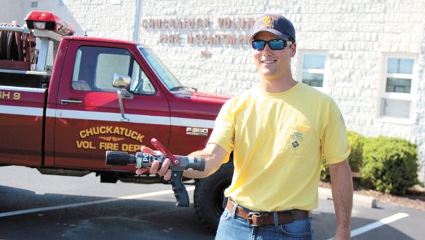 At the organization’s headquarters Monday, Chuckatuck Volunteer Fire Department volunteer Jay Saunders shows the brush truck that will be outfitted with a new hose and foam sticks, which go inside the nozzle he holds to create foam, thanks to a Virginia Department of Forestry grant.