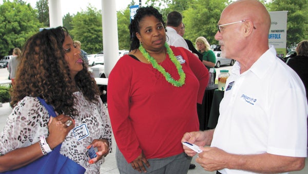 From left, Jennifer Hoffman and Terrell Munden from Liberty Mutual chat with Chuck Dunlap of Greg Garrett Realty at the Hampton Roads Chamber of Commerce’s Mingle on Main Street at the Suffolk Visitor Center Pavilion on Thursday.