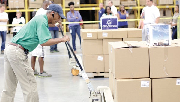 Curtis Rucker of Virginia Beach, an employee of Damco in Chesapeake, cranks up the pallet jack during the LogistXGames competition at the Ace Import Redistribution Center at CenterPoint on Friday. After four events, Damco placed third in the event, behind second-place Target and first-place Givens.