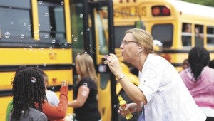 Julie Plasencia, a gifted resource teacher at Hillpoint Elementary School, gives students a bubbly sendoff at the end of Suffolk Public Schools’ last day of the school year on Friday.