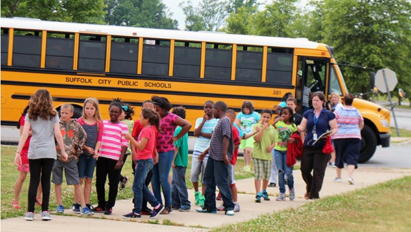 Students and faculty file off a school bus that was used to evacuate them to King’s Fork High School. (Matthew Ward/Suffolk News-Herald)