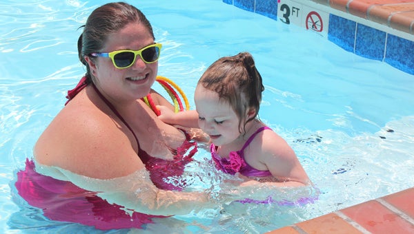 On Thursday afternoon, Katie Lamas and her 2-year-old niece, Lacey Lamas, escape the heat in the Steeplechase neighborhood pool at Bennett’s Creek. 