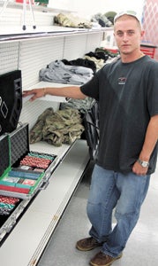 Ronnie Hamilton Jr., manager of Suffolk Pawn and Gun, shows some poker sets in stock at the store. The new store will open in North Suffolk by July 1.