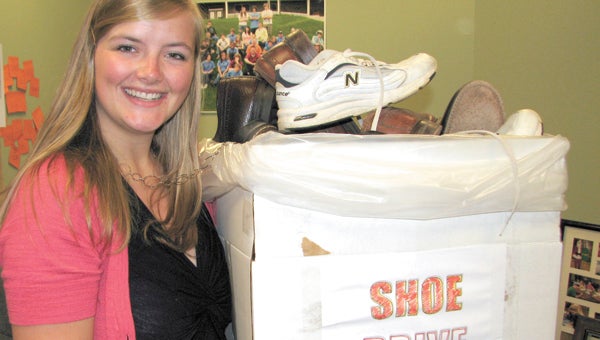 Jordan Bates, the youth and missions intern at Westminster Reformed Presbyterian Church, shows off some of the shoes already donated to the church in support of an upcoming missions trip.