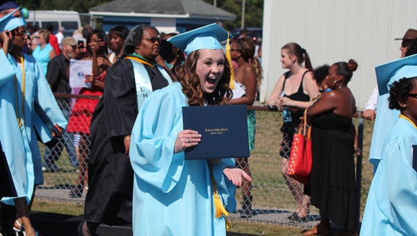 Lakeland High School graduate Stephanie Boles expresses her excitement to family members watching her walk off the athletics field with her diploma. (MATTHEW A. WARD/SUFFOLK NEWS-HERALD)