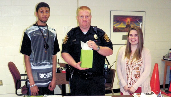 Nansemond River High School students Johnnie Whitaker and Margaret Runyon present a gift to Master Police Officer David Chapman after he spoke on issues including gangs and sexting. (Submitted Photo)