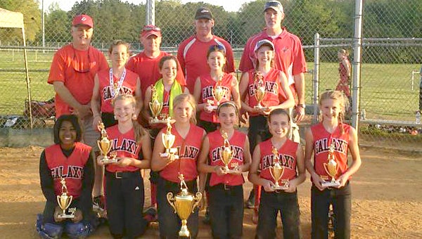 The 12U team for Galaxy Fastpitch celebrates after winning the NSA's Virginia Cup at the 12U level. The squad has also won the NSA's 12U Class B State Championship. Front row, from left: Loren Hudson, Lexy Massey (Suffolk), Ashlyn Baker, Cameron Pagan (Suffolk), Faith Kitchen and Bailey Johnson; middle row, from left: Valerie Cagle, Peyton Coleman, Claire Smeltzer and Maison Myers; back row, from left: coaches Woodie Kitchen, Jodie Coleman, Mark Cagle and Marcus Myers; not pictured: Jordyn Brink. (Photo submitted by Mark Cagle)