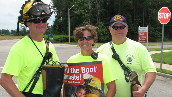 Firefighter Chris Asbell, Lt. Laurina Lopez and Firefighter David Dickens collect donations for the “Fill the Boot” campaign last year. The international event supports the Muscular Dystrophy Association.