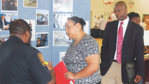 George Bailey Jr. and Terence Eley waiting in line behind them, Gracie Robinson talks to Suffolk police officer Dwayne Wiggins about joining the force. Organizers reported a strong turnout at Friday’s Job Fair and Career Expo, held at King’s Fork Middle School. 