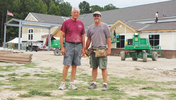 A church has been going up fast near Smithfield. At the construction site Wednesday, L.J. Smith, one of the project’s coordinators, stands beside Harvest Fellowship Baptist Church Associate Pastor Ronnie Bunch.