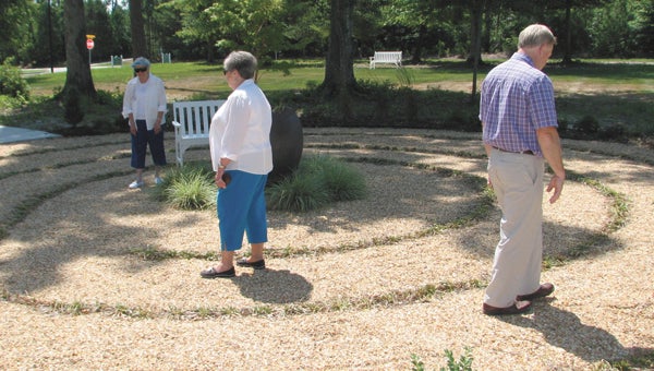 : From left, Lake Prince Woods residents Betty Anne Lyle and Jane Sommers and director of spiritual life Woodie Rea walk the new labyrinth at Lake Prince Woods.