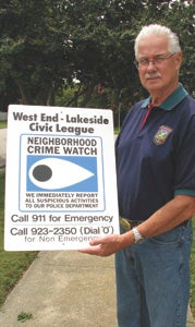 James Strickland, president of the West End-Lakeside Civic League, shows off one of the neighborhoods’ new Neighborhood Watch signs that aim to deter criminals from the area.