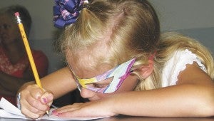 Audrey Sawyer creates a mini-comic during a workshop at Morgan Memorial Library on Wednesday. The workshop fell on Batman Day, and some of the kids wore masks in tribute.