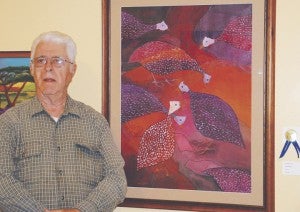 Artist W. Martin Jones stands with his painting “Guineas,” which won him the 2013 Suffolk Art League Juried Exhibition. The honor comes with the opportunity for a one-man show the following year. His exhibit, “Inspirations,” opens Saturday.