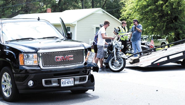 Bystanders help a wrecker driver load a motorcycle following a crash on Godwin Boulevard on Saturday afternoon. One man was airlifted to Sentara Norfolk General Hospital from the Chuckatuck Volunteer Fire Department Saturday afternoon after the head-on collision between his motorcycle and an SUV headed to Smithfield. The couple in the SUV was uninjured.