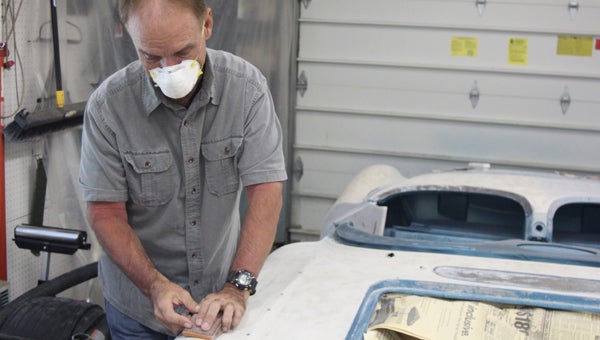 In his North Suffolk garage, Dwight Farmer works on restoring his 1959 Corvette.