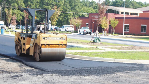 A worker paves the driveway into Pioneer Elementary School earlier this week. The school is preparing to open for the first day of school on Sept. 2, with teachers due to move in Monday.