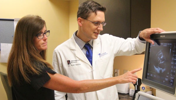At Bon Secours Health Center at Harbour View, Kristen Tedeschi and cardiologist Ryan Seutter demonstrate echocardiography equipment that allows earlier detection of cardiovascular disease.