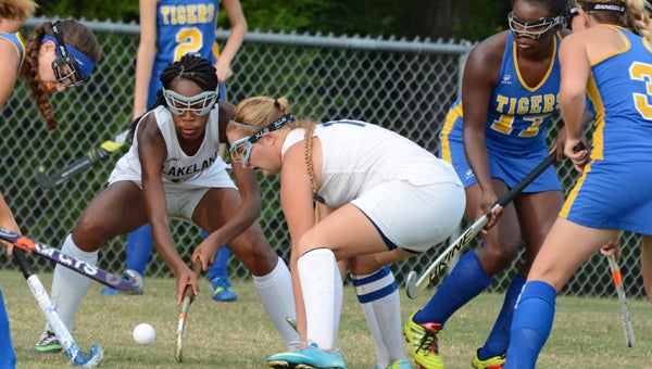Lakeland High School juniors Chaunsa Saunders, center in white, and Stasha Waterfield, right of her, compete against visiting Oscar Smith High School for possession of the ball on Wednesday. (Melissa Glover photo)