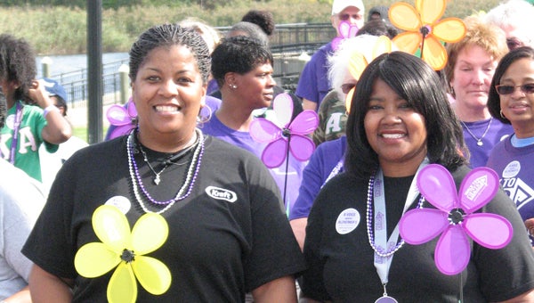 Alfreda Russell and Barbara Peterson, members of the Planters Peanuts team for the Walk to End Alzheimer’s, set off on the walk from Constant’s Wharf on Saturday morning. Walkers carried colored flowers representing their connections to Alzheimer’s — yellow meant the walker is supporting or caring for a loved one with the disease, and purple means the walker has lost a loved one.