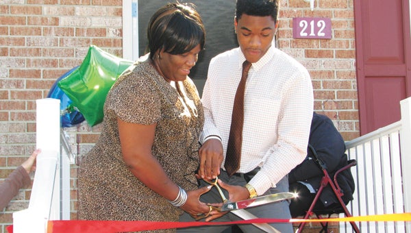 Malika Traynham and her son, Qudree Willis, cut the ribbon at their new home on Saturday.
